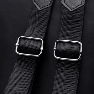 Black nylon backpack shoulder strap with silver metal buckle and leather reinforcement