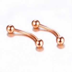 Detail of curved rose gold stainless steel piercing jewelry with polished ball ends