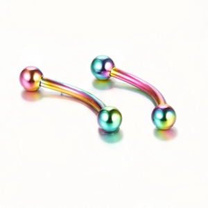 Close-up of two rainbow PVD curved barbells for eyebrow and lip piercings on white background