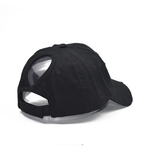 Detail of the black cotton baseball cap showing the ponytail hole and velcro strap