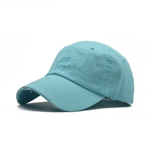 Detail of distressed light blue cotton baseball cap with ripped brim and vintage texture