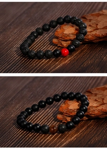 Detail of 8mm volcanic lava stone and matte onyx beads on wood and bark background