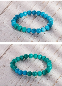 Close-up of vintage turquoise bead bracelets with natural black veined texture on wood