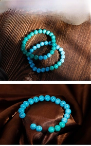 Detail of turquoise bead bracelets with black matrix veins on wood and velvet texture