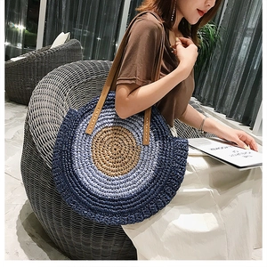 Détail du sac de plage rond en paille tressée avec dégradé bleu et anse en cuir
