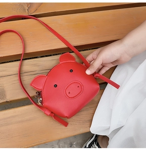 Detail of red cartoon pig crossbody bag with adjustable strap for kids fashion