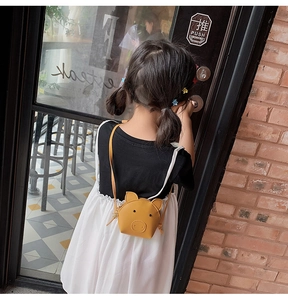 Detailed view of yellow pig-shaped cartoon crossbody bag with metal zipper for kids