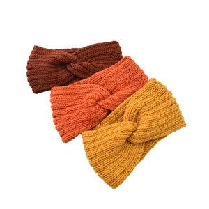 Detailed texture of knitted cross headbands in coffee, orange and ginger yellow colors