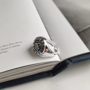 Macro shot of 925 silver eye ring with runes and S925 hallmark on vintage book