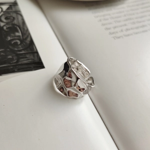 Detail of 925 sterling silver ring with irregular hammered texture on open book page