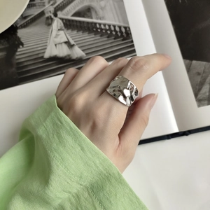 Close-up of irregular hammered texture 925 silver ring with natural metallic reflections