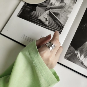 Detailed close-up of a silver 925 irregular textured ring worn by a fashion model
