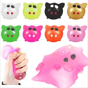 Multiple colorful pig squeeze toys showing elastic deformation and squishy TPR texture