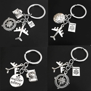 Silver travel-themed keychain set featuring airplane camera compass and globe charms