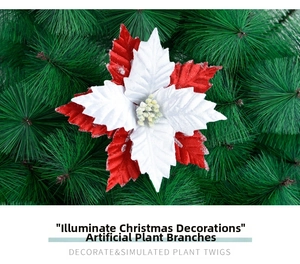 Detail of red and white fabric poinsettia with glitter petals on pine needles background