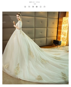 Detail of bridal gown with gold embroidery, lace appliques and long train luxury dress