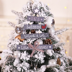 Rustic wood Christmas hanging sign with star and bird on a festive tree backdrop