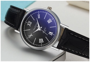 Detail view of the black crocodile leather strap and blue gradient dial on the watch