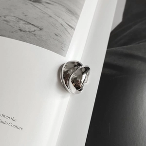 Macro detail of the fluid metal 925 silver ring with polished mirror finish on a book