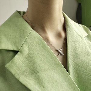 Close-up of S925 silver O-chain necklace with a sparkling cubic zirconia letter X pendant
