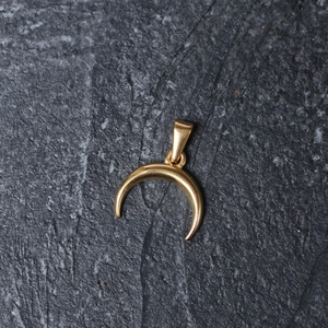 Detailed top view of a polished 18k gold-plated stainless steel crescent moon pendant