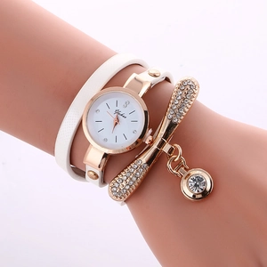 Close-up of a white wrap-around watch with a gold rhinestone bracelet on a wrist