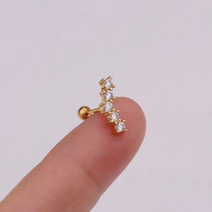 Detailed view of a gold flower stud earring with five sparkling zircon stones on a hand