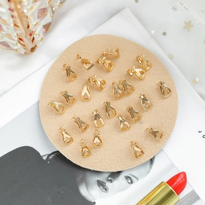 Golden triangle earring clips for DIY jewelry making on a beige velvet tray