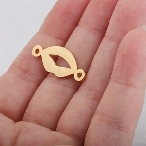 Polished gold stainless steel lip-shaped pendant charm held in hand showing scale