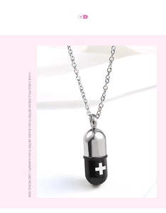 Detail showing two-tone capsule pendant with cross logo on white fabric background