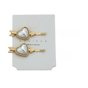 Detailed view of gold arrow hair clips with heart pearls showing 4.3cm length and 9g weight
