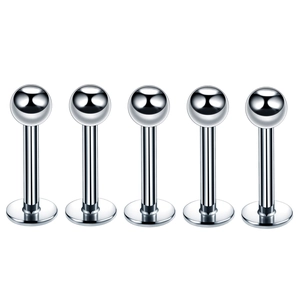 Five pieces of silver stainless steel lip and ear piercing studs with ball tops on white background