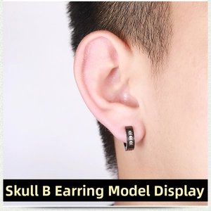 Close-up of black punk ear clip featuring skull patterns on a male model ear