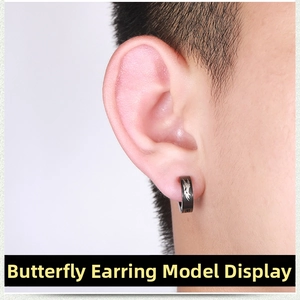 Detail view of black punk ear clip for men featuring a white butterfly print on titanium steel