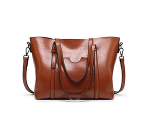 Détail d'un sac cabas marron en cuir texturé rétro avec bandoulière réglable et finition brillante