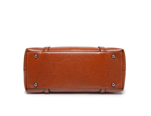 Vue détaillée du fond du sac cabas en cuir marron avec quatre clous de protection en métal