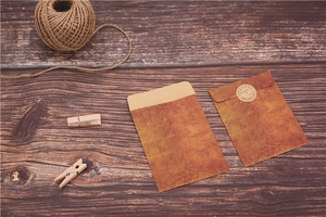 Vintage brown kraft paper envelope for jewelry packaging with seal on wood background