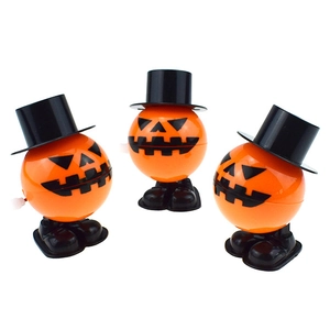 Close-up of three orange wind-up pumpkin toys with black hats for Halloween gifts