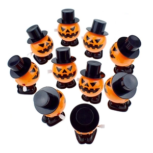 Collection of ten pumpkin clockwork toys with black top hats and white winding knobs
