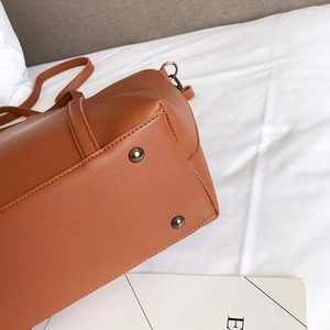 Detail view of caramel PU leather bucket bag base with four protective metal rivets