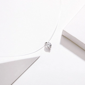 Detailed close-up of a single round cubic zirconia on a transparent fishing line necklace