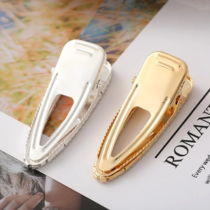 Detail of gold and silver teardrop hair clips with shimmering pavé rhinestones