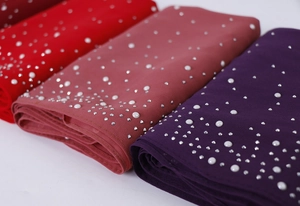 Detail of premium pearl and rhinestone embellishments on colorful chiffon headscarves