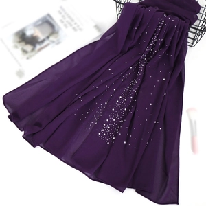 Detalle de bufanda de gasa violeta oscuro con perlas blancas y decoración de diamantes