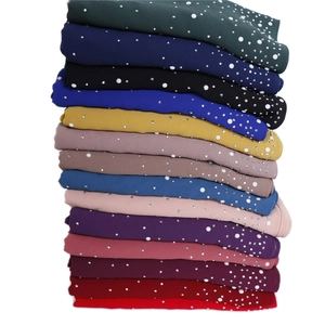 Detail of premium chiffon shawls with decorative white pearls and shimmering rhinestones