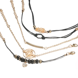 Nahaufnahme der böhmischen Goldketten-Armband-Sets mit schwarzen Perlen und Herzanhängern