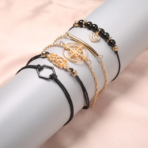 Detailansicht des fünfteiligen Mehrschicht-Armbandsets mit Kompassanhänger auf Display
