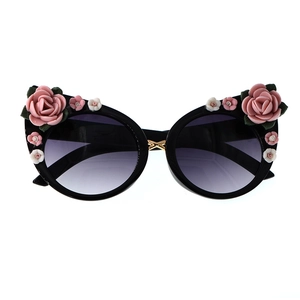 Detail of black cat eye sunglasses with 3D resin flowers and purple gradient lenses