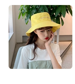 Close-up of yellow chenille bucket hat with delicate embroidery on soft fabric