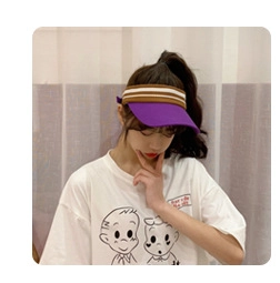 Close-up of a purple sun visor hat with a brown and white striped knitted headband detail